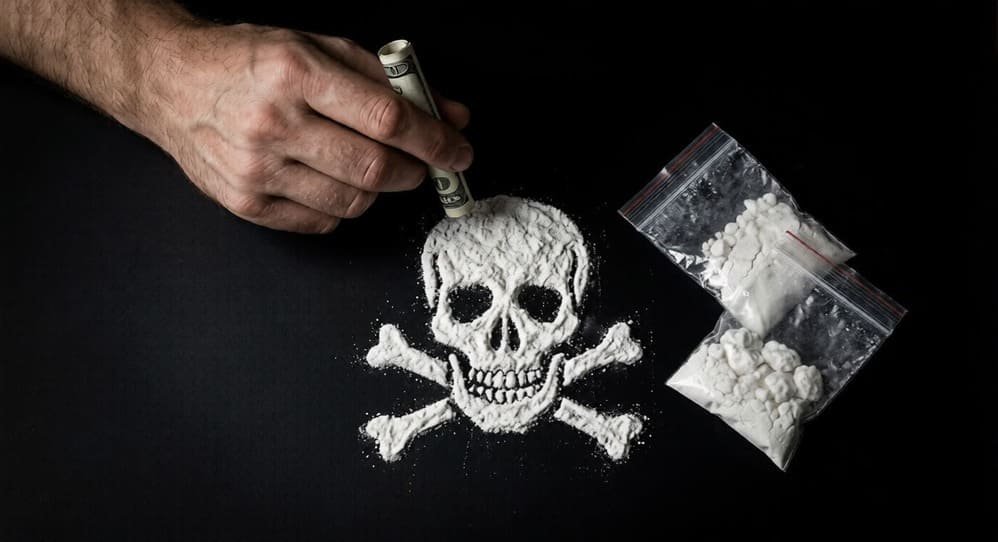 Danger-of-drugs-hand-with-rolled-bill-powder-skull-and-plastic-bags